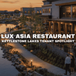 Lakeside restaurant and bar patio at Kettlestone Lakes in Waukee, Iowa, with outdoor dining, evening lighting, walking paths, and modern mixed-use storefronts.