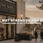 Stone Mat Strength and Motion Studios at Kettlestone Lakes in Waukee, Iowa with boutique fitness classes, lakefront walkways, landscaped sidewalks, and nearby wellness and dining businesses.