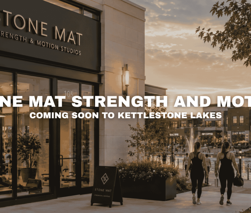 Stone Mat Strength and Motion Studios at Kettlestone Lakes in Waukee, Iowa with boutique fitness classes, lakefront walkways, landscaped sidewalks, and nearby wellness and dining businesses.